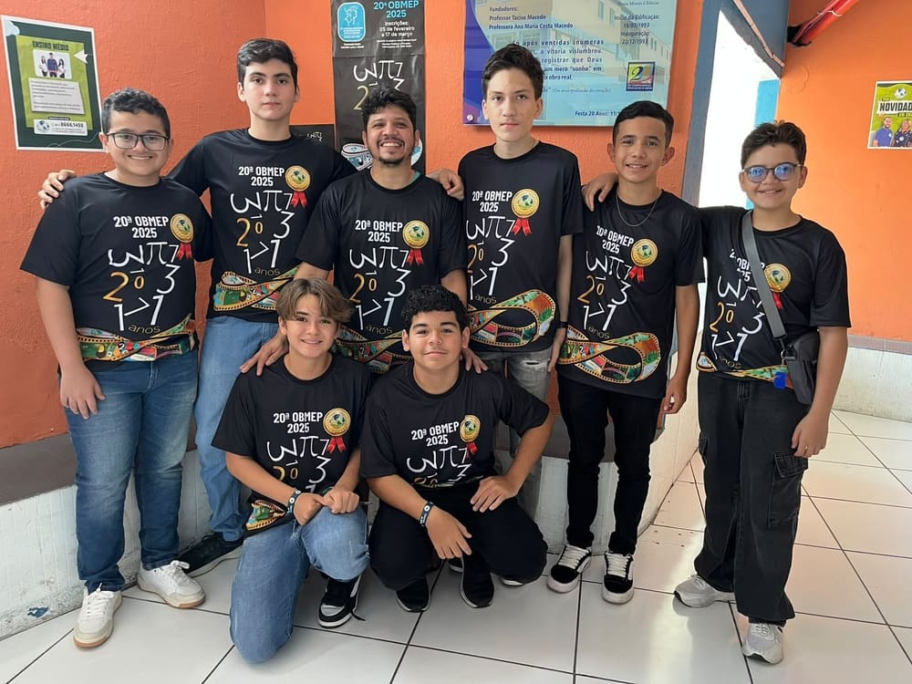 Alunos com a camiseta da 20ª OBMEP, de 2025, reunidos no colégio com um professor