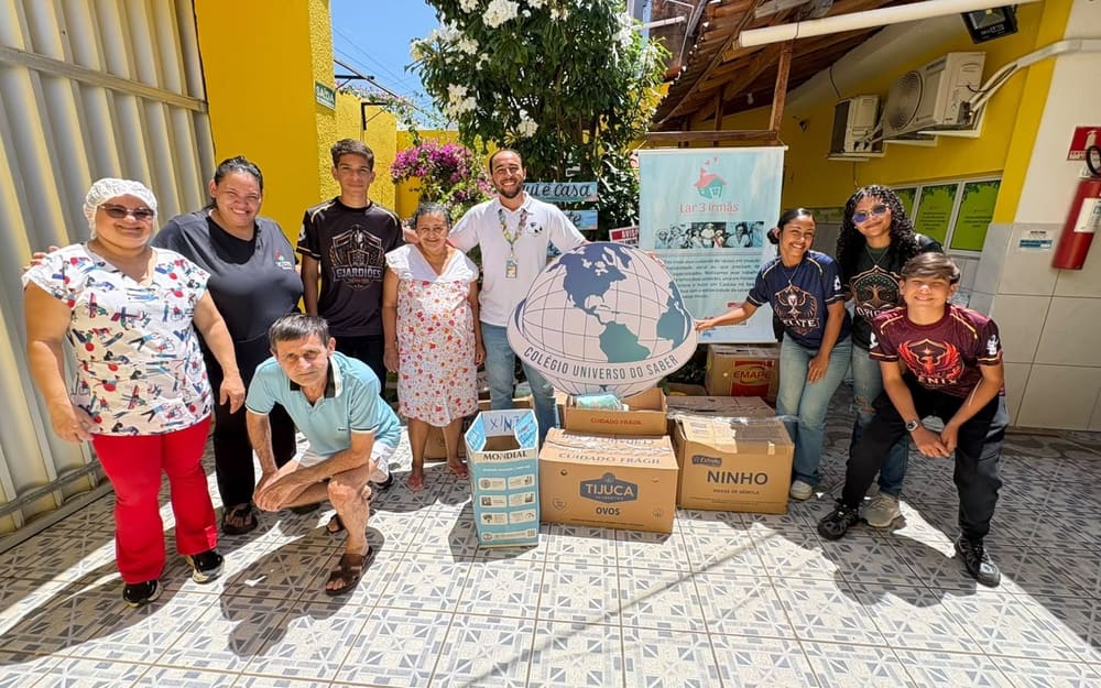 Alunos, professores e moradoras do bairro em volta das caixas de doação do projeto social, no pátio do colégio