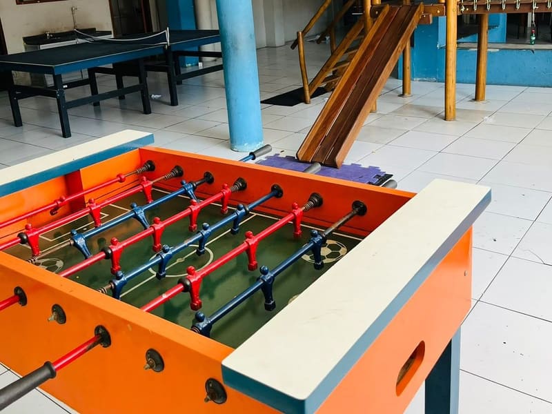 Área de recreação, com o pebolim, a mesa de pingue-pongue e o escorregador